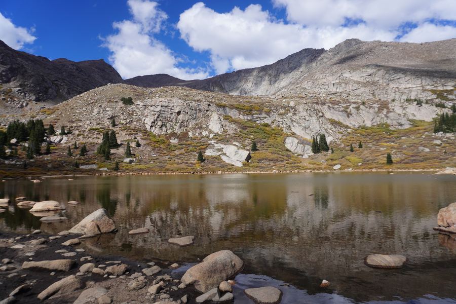Alpine lake reflecting rocky peaks and clouds