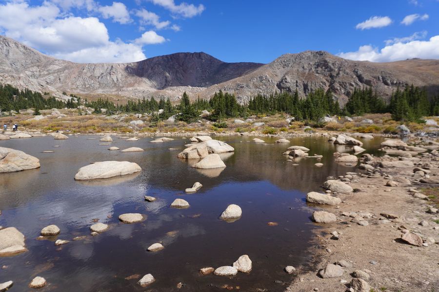 Boulders scattered across a shallow alpine lake